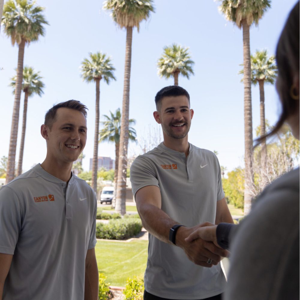 A photo of two friendly Phoenix Scottsdale Canyon Cleaning Solutions window and power washing professionals working at a home. 